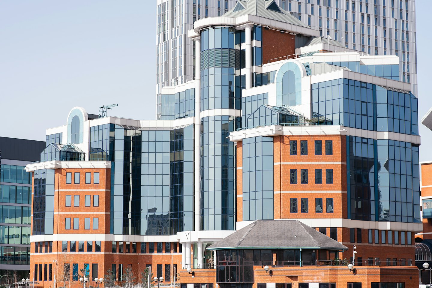 Modern office buildings featuring blue glass and red brick facades.